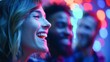 © NovaVision - A woman is laughing with friends in a colorful, neon-lit party setting with blurred lights.