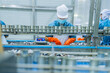 © ultramansk - Skilled technician in a food factory handling canned products, highlighting efficiency, strict hygiene, and quality assurance in the food processing industry.