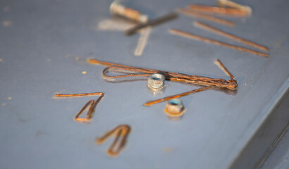 Wall Mural - Close up of old rusty nails on a metal surface with blurred background