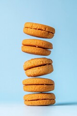 Poster - Architectural Cookie Design Minimalist Golden Macarons Stacked in Gravity-Defying Balance - Culinary Art and Modern Food Styling Trend