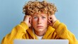 © Nataliia_Trushchenko - Young man with curly hair is wearing a yellow sweater and listening to music