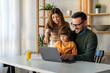 © NDABCREATIVITY - Happy single parent with cute excited small kid son using laptop computer at home. Technology
