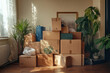 © Sandu - Cardboard boxes stacked inside a bright room with houseplants, preparing for a move or decluttering project