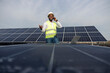 © Dusan Petkovic - Portrait of smiling interracial electrical engineer standing at solar farm and having phone call with investors.