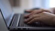 © lenblr - Woman opening and typing on laptop at hotel