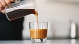 Barista pouring lungo coffee into a glass focused expression minimalist coffee shop soft diffused light close-up shot, Realistic Photo