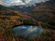 © AmazingAerialAgency - Aerial view of maple lake surrounded by colorful autumn foliage and majestic mountains, Payson, Utah, United States.