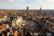 © AmazingAerialAgency - Aerial view of the beautiful medieval bell tower Belfort and bustling Market Square in the picturesque old town, Bruges, West Flanders, Belgium.