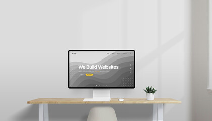 Leinwandbilder - Modern desk setup with computer displaying a concept web design for a creative studio, 'We Build Websites' headline, plant and window in soft-lit office space