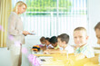 © JackF - Portrait of positive boy pupil sitting at desk studying in classroom