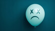 © Inspire Shots Hub - Light-blue balloon with a sad face drawn on it against a teal background, conveying feelings of disappointment or sadness, suitable for emotional concepts or designs