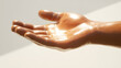 © Aditya - Close-up of a hand with glistening skin, possibly oiled or moisturized. The hand is open, palm up, suggesting offering or receiving. Soft lighting enhances the smooth texture.