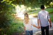 © peopleimages.com - Back view of couple, hand holding and walking in park for love, bonding with care and support in healthy relationship. Man, woman and outdoor for date with romance, trust and commitment for marriage