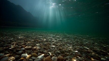 Aufkleber - Morning light dances over a tranquil emerald lake, highlighting the smooth stones below as rays of dawn ripple across the serene waters, creating a peaceful atmosphere