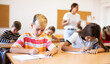 © JackF - Portrait of focused preteen schoolboy writing exercises in workbook during lesson in classroom ..