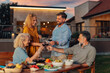 © Zamrznuti tonovi - Happy family toasting red wine at barbecue dinner in garden