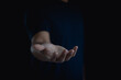 © THAWEERAT - Person is standing and show an outstretched hand with an open palm. Business man showing empty hand and presenting isolated on black background. Hold, give, receive, help, gesture, present concept.