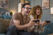 © Miljan Živković - couple man and woman husband wife play console video games at home