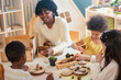 © lordn - Preschool teacher guides a diverse group of children in a natural materials activity in a bright, creative classroom setting focused on hands-on learning.