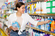 © JackF - Young woman looking to buy laundry detergent in supermarket