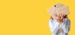 © Pixel-Shot - Young woman hiding face behind books on yellow background with space for text