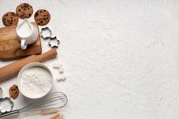 Wall Mural - composition with wooden rolling pin, kitchen utensils and ingredients for dough on white background