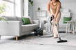 © Pixel-Shot - Young woman vacuum cleaning carpet in living room