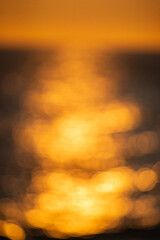 Wall Mural - the image is a blurry, orange sunset over the ocean