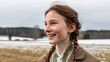 © Nataliia_Trushchenko - Young girl with brown hair and a green scarf is smiling in a field. Concept of happiness and warmth, as the girl appears to be enjoying her time outdoors