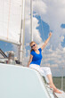 © danmorgan12 - Sea Travel Concepts. One Winsome Happy and Smiling Positive Caucasian Sailor Woman Sitting Relaxing on White Yacht At Daytime on Board.