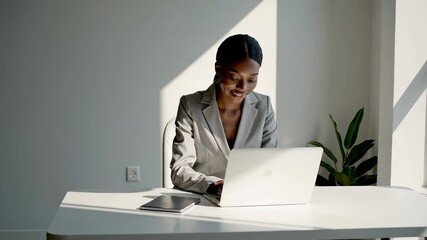 Aufkleber - Sunlight streaming through office window highlighting african american businesswoman working intently on laptop. Displaying professional confidence and focused energy while managing corporate project