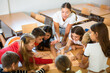 © JackF - Teacher and schoolchildren play a table game in school class