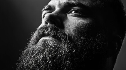 Poster - High-contrast portrait of a man with a thick beard captured in studio lighting showcasing texture and emotion