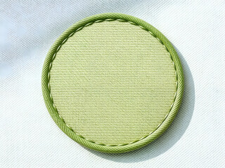 round green stitched patch on neutral fabric background, perfect for clothing label or craft themes.