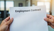 © Margarita - Hands Holding an Employment Contract in a Modern Office Setting for Business Articles, HR Blogs, Job Search Resources, and Corporate Communication