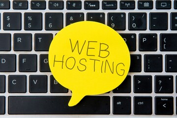 Wall Mural - yellow speech bubble on top of laptop keyboard with text web hosting. business and technology concep