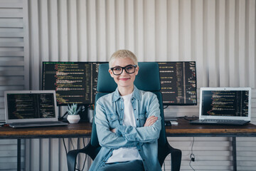 Confident Female IT Professional Posing in a Modern Coding Workspace with Multiple Monitors
