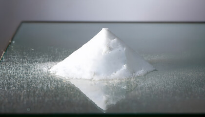 Fototapete - Pyramid-shaped mound of white powder on a reflective surface
