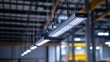 © Koplexs-Stock - Industrial led lighting fixtures hang in a large warehouse or factory setting.