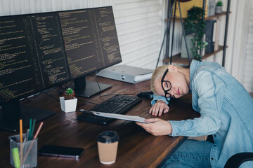young professional woman in casual attire visibly exhausted while working on complex programming tas