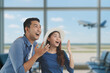 © Mallika - Happy  young Asian couple at the airport terminal, excited and ready for their trip. Travel and vacation concept with background of airplane taking