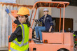 © kanpisut - WoMan worker at forklift driver happy working in industry factory logistic ship. Woan forklift driver in warehouse area..Forklift driver sitting in vehicle in warehouse