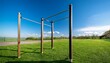 © Jeffrey - tall and slim pull up bar stands against clear blue sky surrounded by green grass creating vibrant and inviting outdoor fitness space
