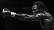 © fangphotolia - Moment of Power: A focused boxer, sculpted in monochrome, unleashes a powerful punch with unwavering determination and strength in the boxing ring.