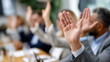 © Desmond - A group of professionals in suits raise their hands in unison during a meeting to show agreement on a decision, during a voting session.