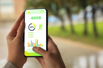 woman using step counting app on smartphone outdoors, closeup