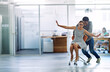 © peopleimages.com - Office, achievement or business women push chair for happiness, investment growth or startup success in company workspace. friends, fun and people with excited face for playing, celebration and win