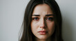 © Produzir - A distraught woman with tears streaming down her face, her eyes filled with sorrow and her expression conveying deep emotional distress.