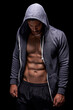 © peopleimages.com - Fitness, serious and man in hoodie on black background for exercise, training and intense workout. Sweat, sports and person with strong body and muscles for performance, wellness and health in studio