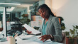 © peopleimages.com - Black woman, documents and reading by computer in office for project, admin and review for proposal. Person, paperwork and pc for research, planning and feedback for perspective at creative agency